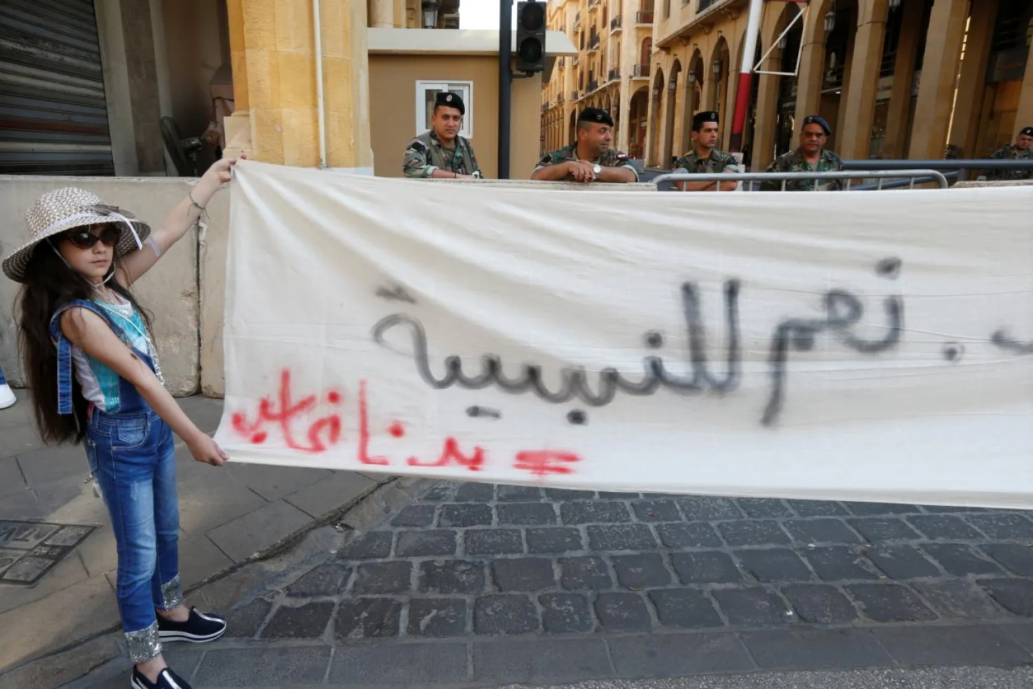 A girl holds a banner during a demonstration against an extension of the parliament's term, in Beirut, Lebanon May 6, 2017. (Reuters)