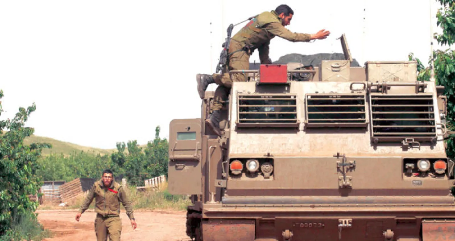 جندي إسرائيلي على قاذفة صواريخ قرب الحدود السورية في الجولان المحتل (أ.ف.ب)