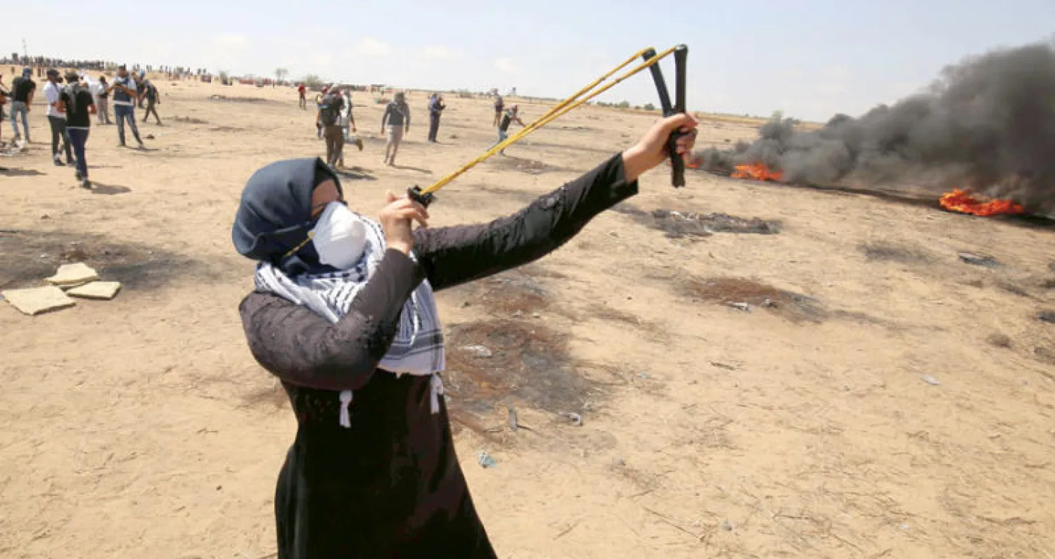 امرأة فلسطينية تشارك في مواجهات مع جنود الاحتلال على حدود قطاع غزة أمس (أ.ف.ب)
مجموعة من الفلسطينيين المشاركين في مسيرات العودة بقطاع غزة أمس (رويترز)