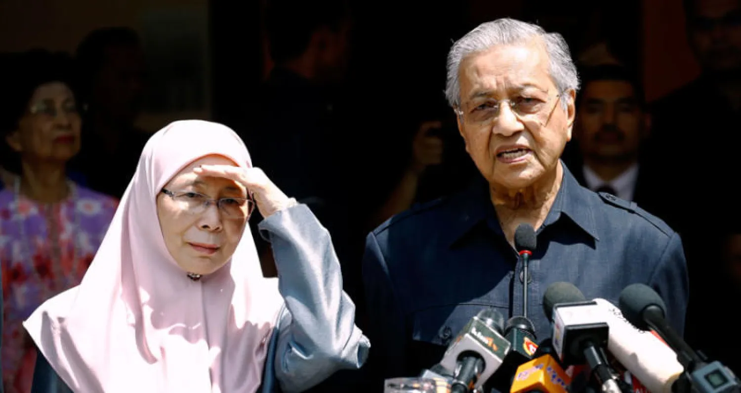 رئيس الوزراء الجديد مهاتير محمد وإلى جانبه وان عزيزة وان إسماعيل زوجة أنور إبراهيم التي انضمت إلى الحكومة نائبةً لرئيس الوزراء (أ.ب)