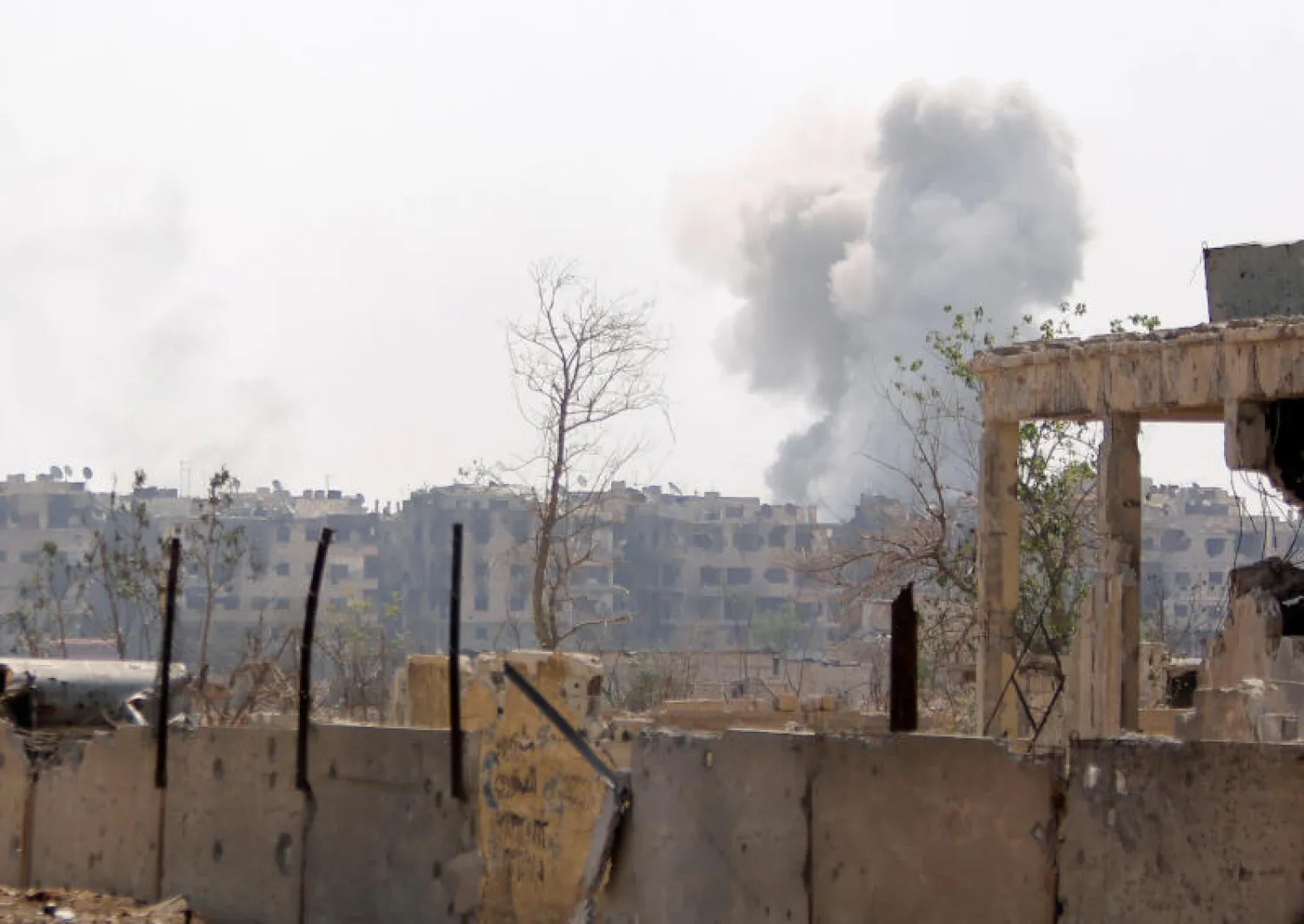الدخان يتصاعد من مخيم اليرموك بسوريا (رويترز)