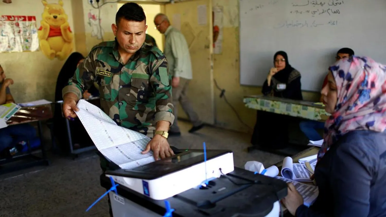 An Iraqi security member votes at a polling station in Baghdad. (Reuters)