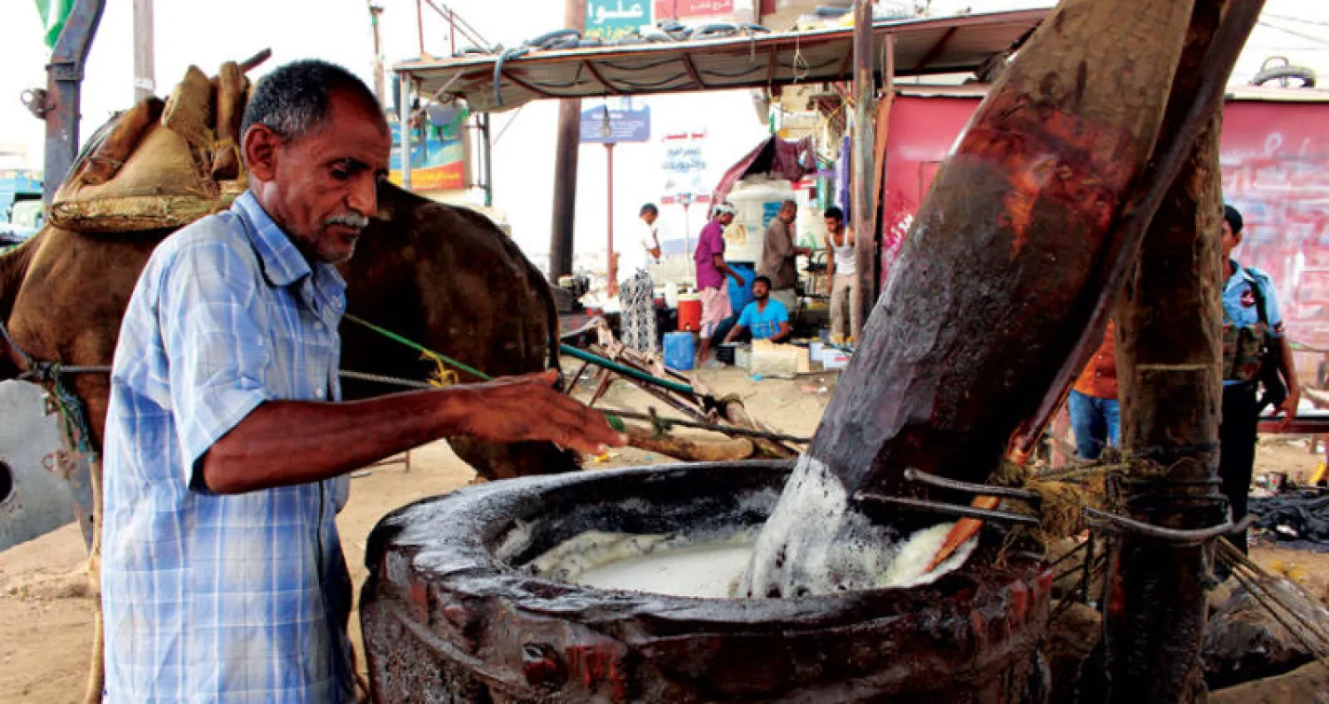 يمني يستخدم مطحنة قديمة لاستخلاص زيت السمسم في منطقة عبس التابعة لمحافظة حجة أمس (أ.ف.ب)