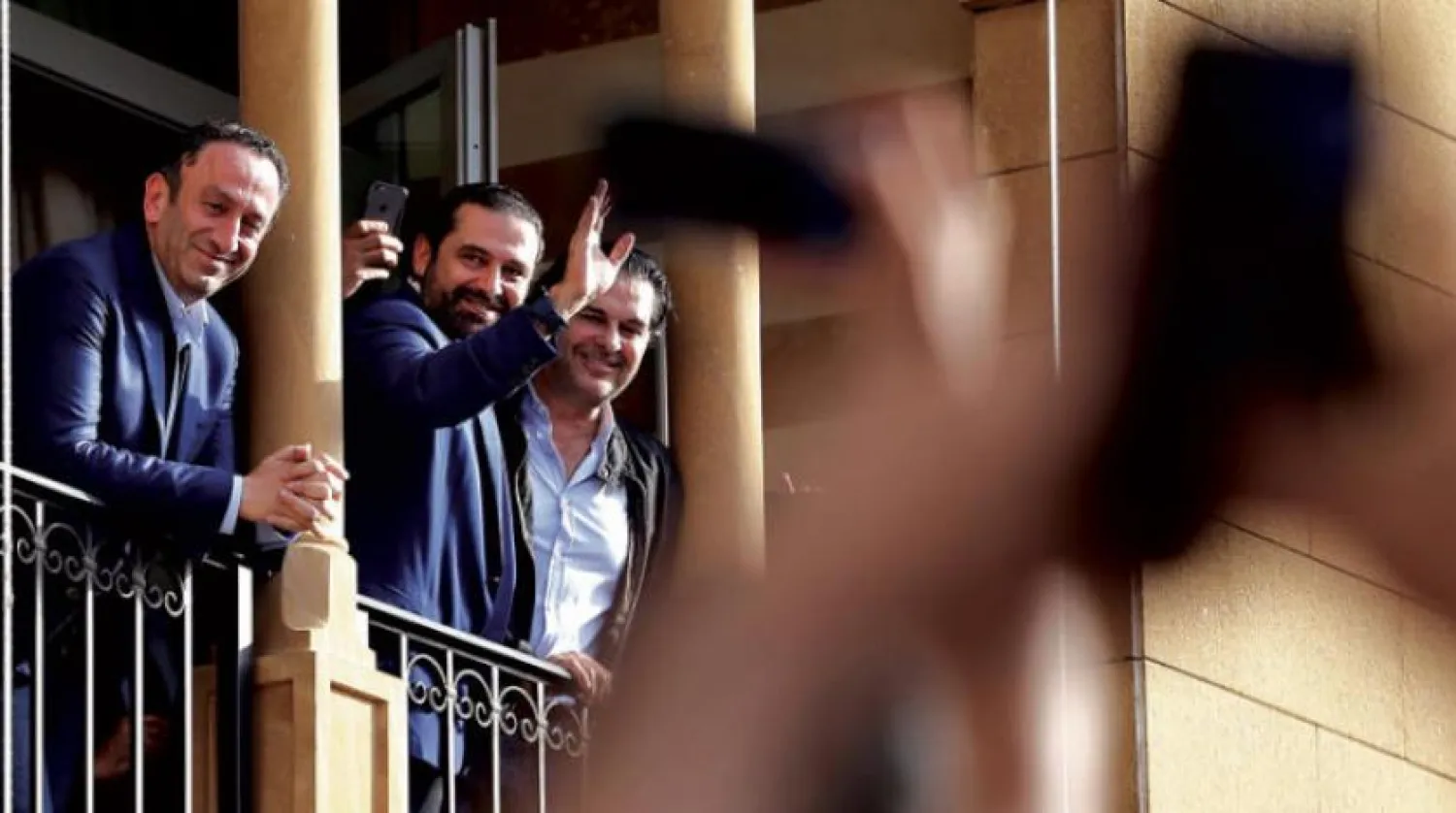Lebanese Prime Minister Saad Hariri, center, waves to his supporters from a balcony at his house in downtown Beirut, Lebanon, Friday, May 11, 2018. (AP Photo/Bilal Hussein)