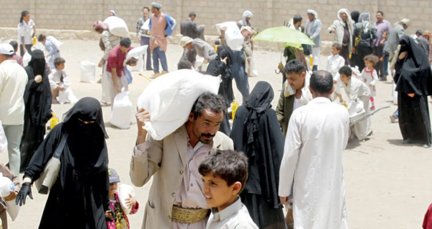 يمنيون يتلقون مساعدات غذائية في ضواحي صنعاء أمس عشية شهر رمضان (إ.ب.أ)