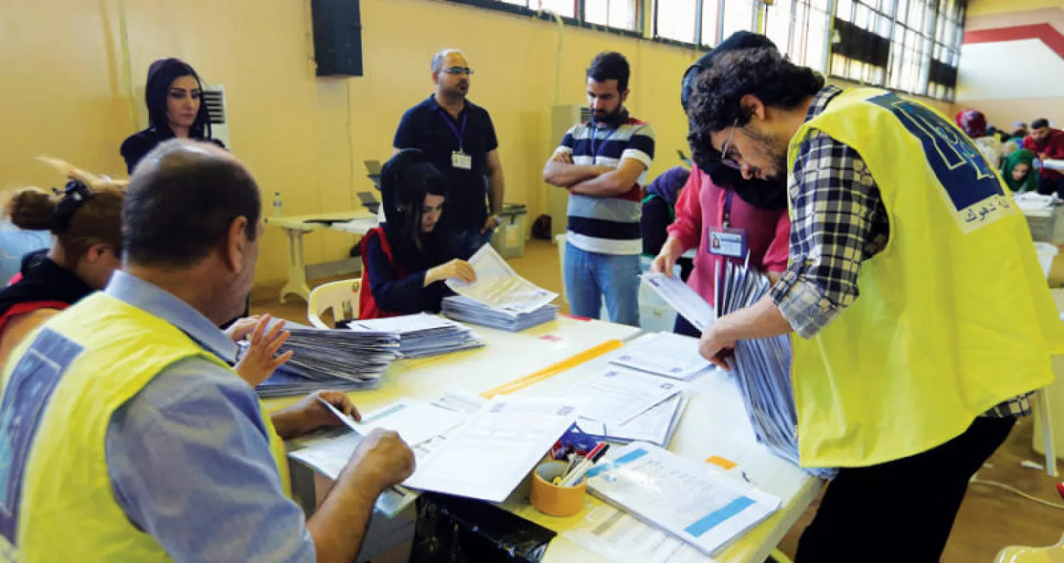 موظفون تابعون للهيئة العليا للانتخابات يواصلون عد الأصوات في دهوك بشمال العراق أمس (رويترز)