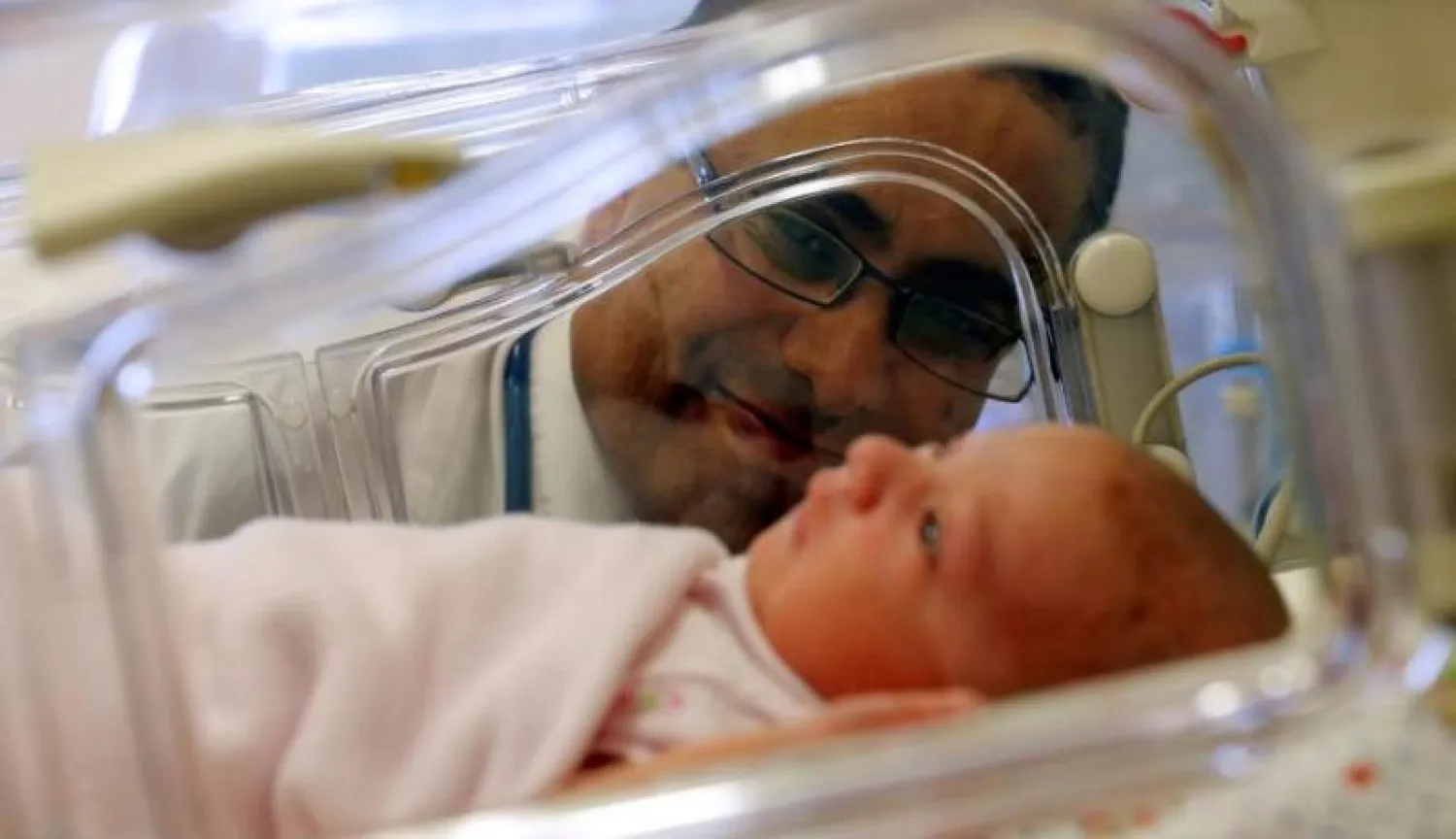 طبيب يفحص طفلاً حديث الولادة (رويترز)