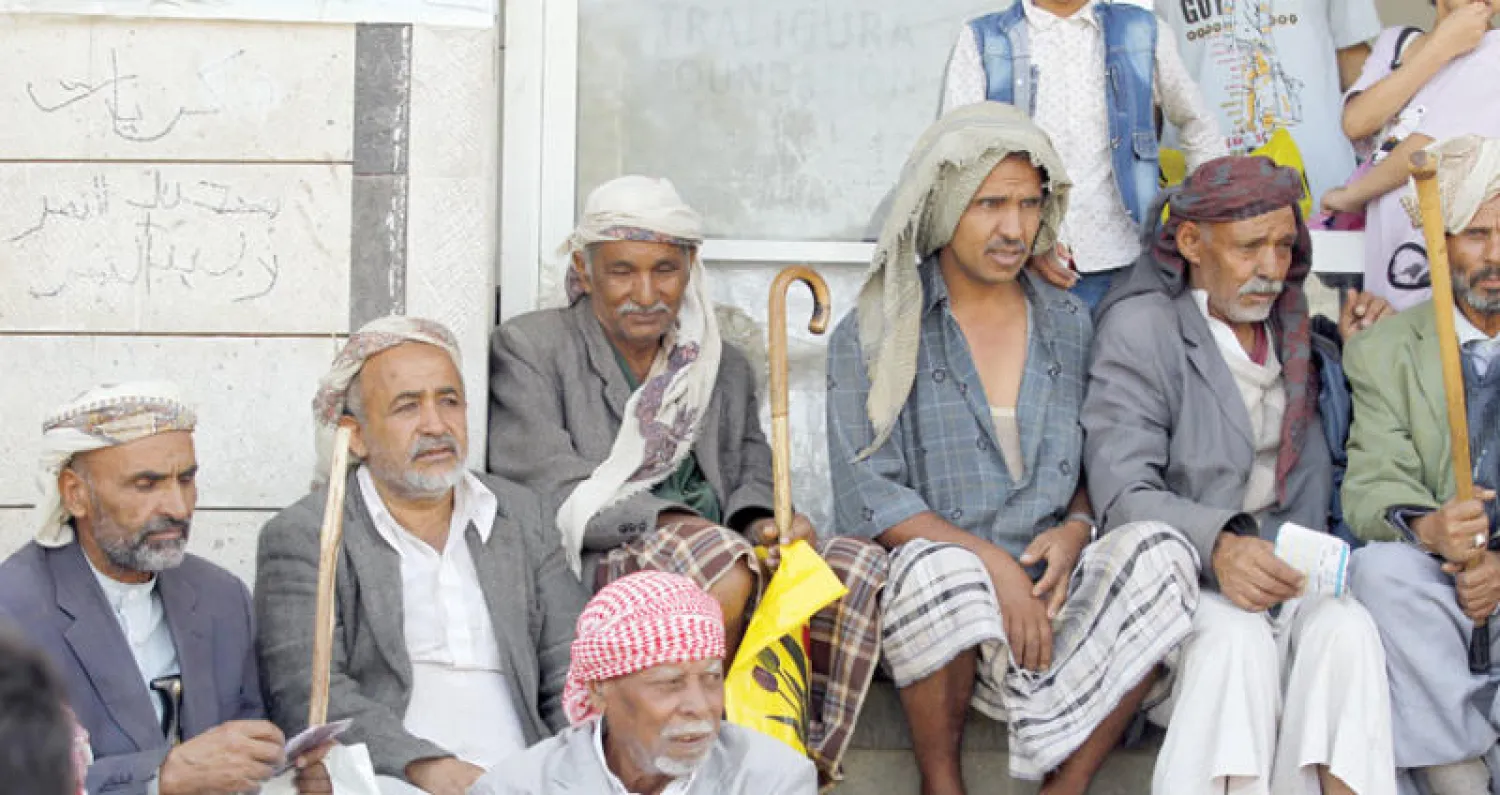 يمنيون ينتظرون أمام جمعية توزع الطعام في صنعاء أمس (إ.ب.أ)