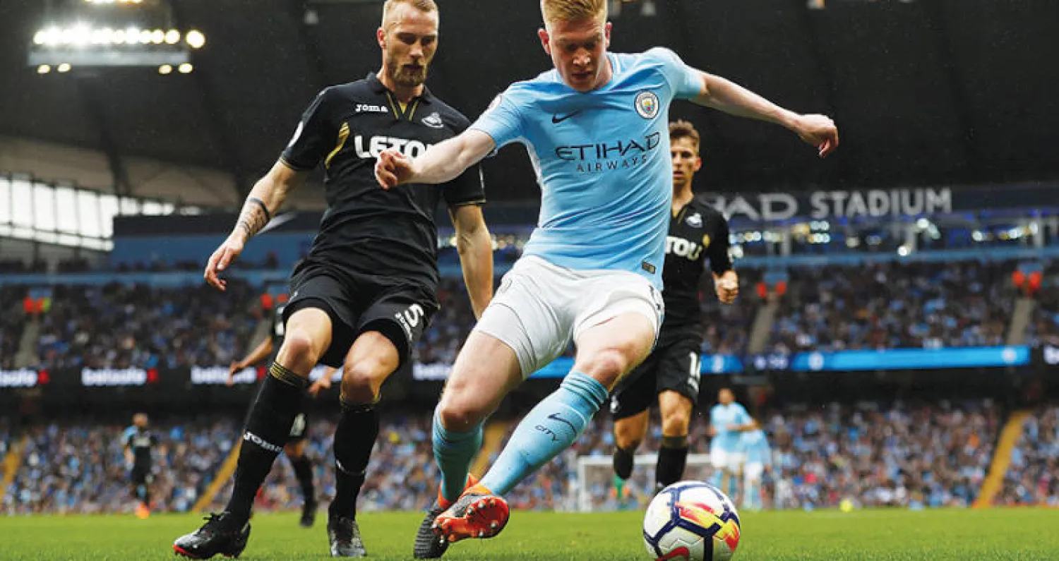 دي بروين نجم مانشستر سيتي يسيطر على الكرة قبل مدافع سوانزي ليثبت أنه أفضل من نفذ فكرة الاستحواذ (رويترز)