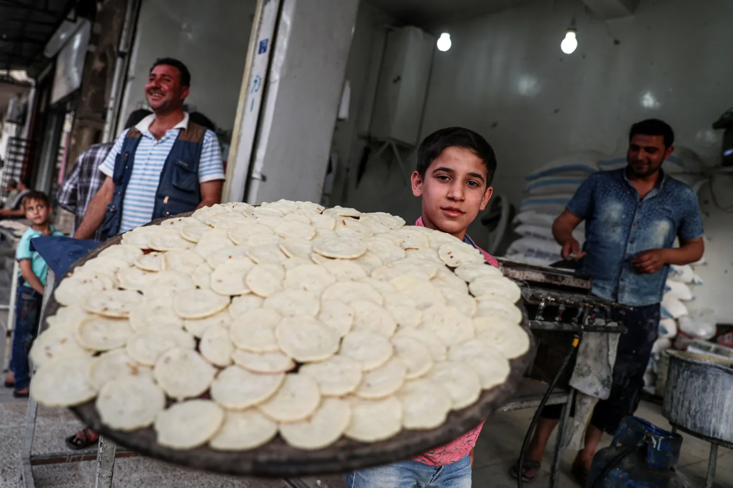 طفل يحمل القطائف في مدينة الباب بسوريا