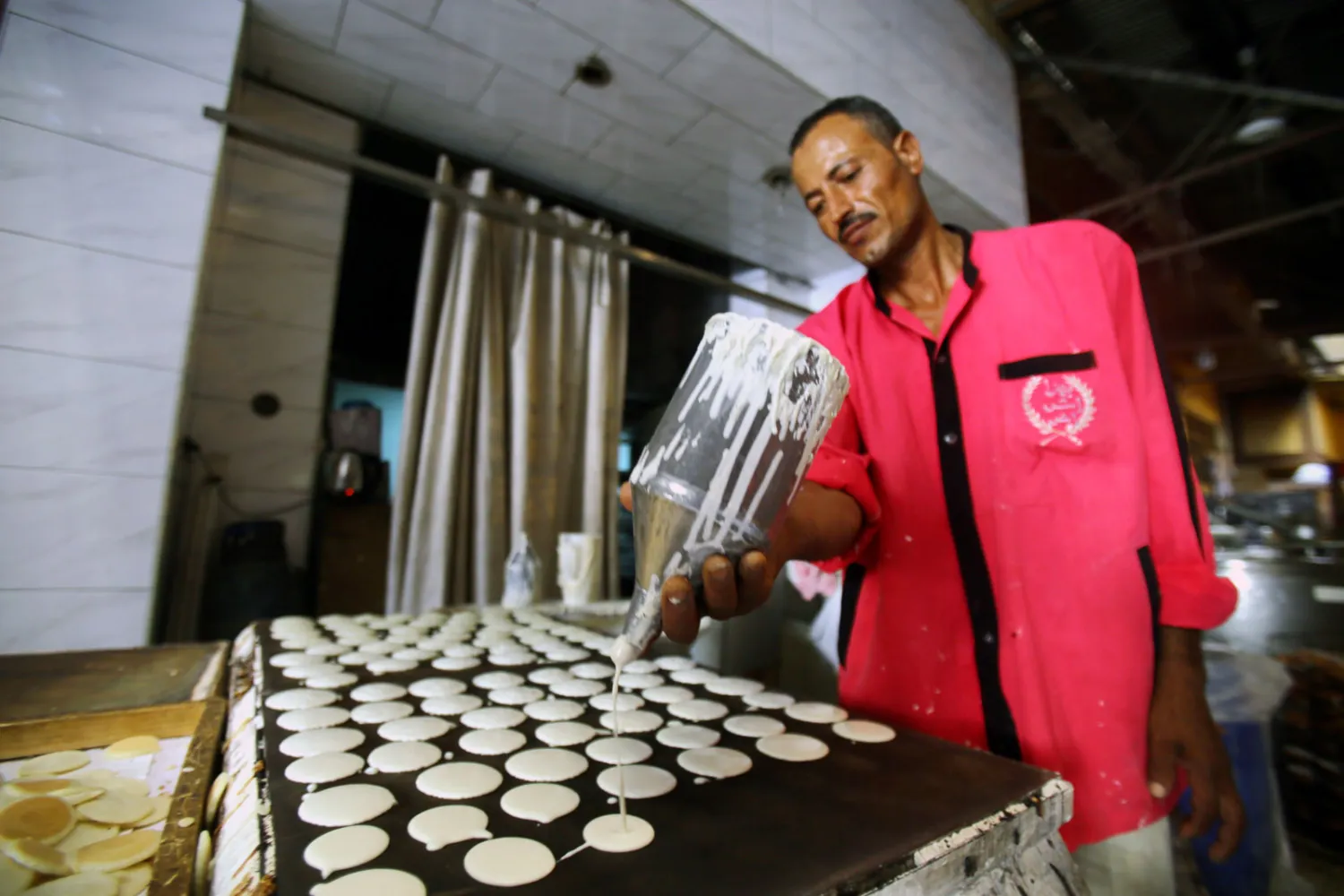 رجل يصنع حلوى القطائف الشهيرة في مصر