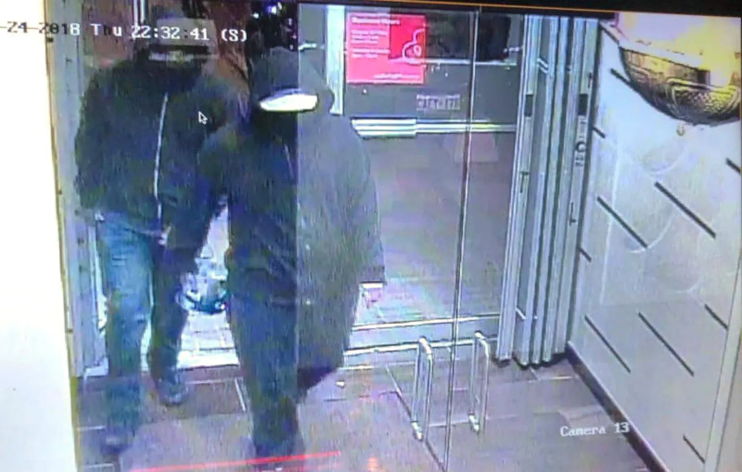 صورة نشرتها الشرطة الكندية على تويتر يظهر فيها رجلان يرتديان ملابس داكنة يدخلان المطعم (أ.ب)