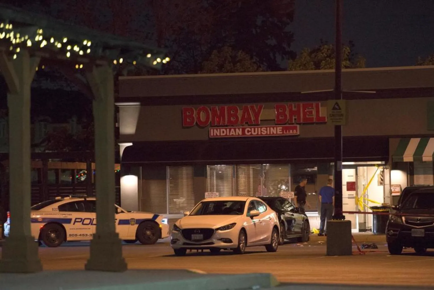 Police stand outside the Bombay Bhel restaurant in Mississauga, Canada Friday, May 25, 2018. (Doug Ives/The Canadian Press via AP) 