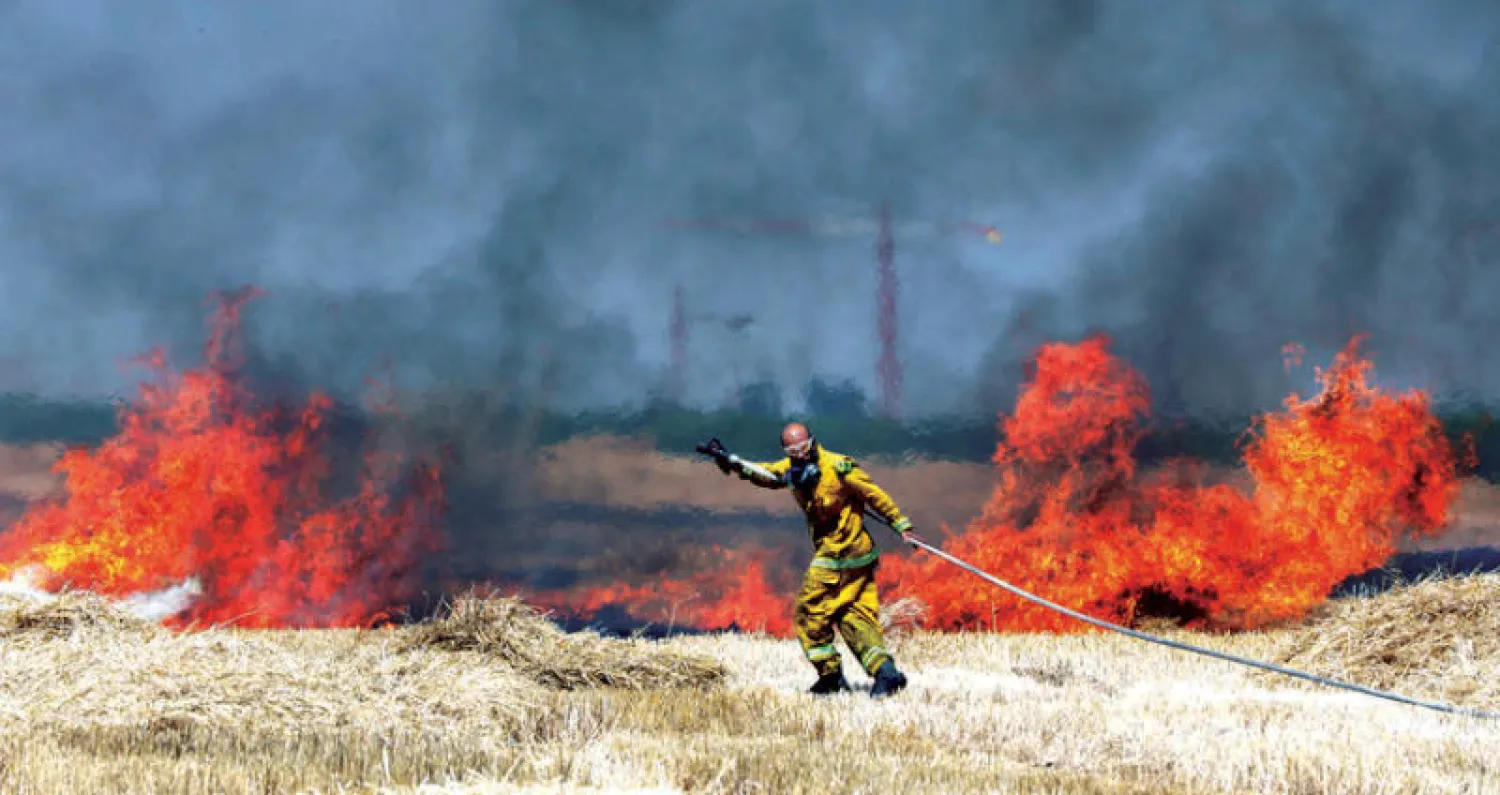 حقول قمح مشتعلة في جنوب إسرائيل بعد إسقاط طائرات ورقية وزجاجات «مولوتوف» عليها (إ.ب.أ)