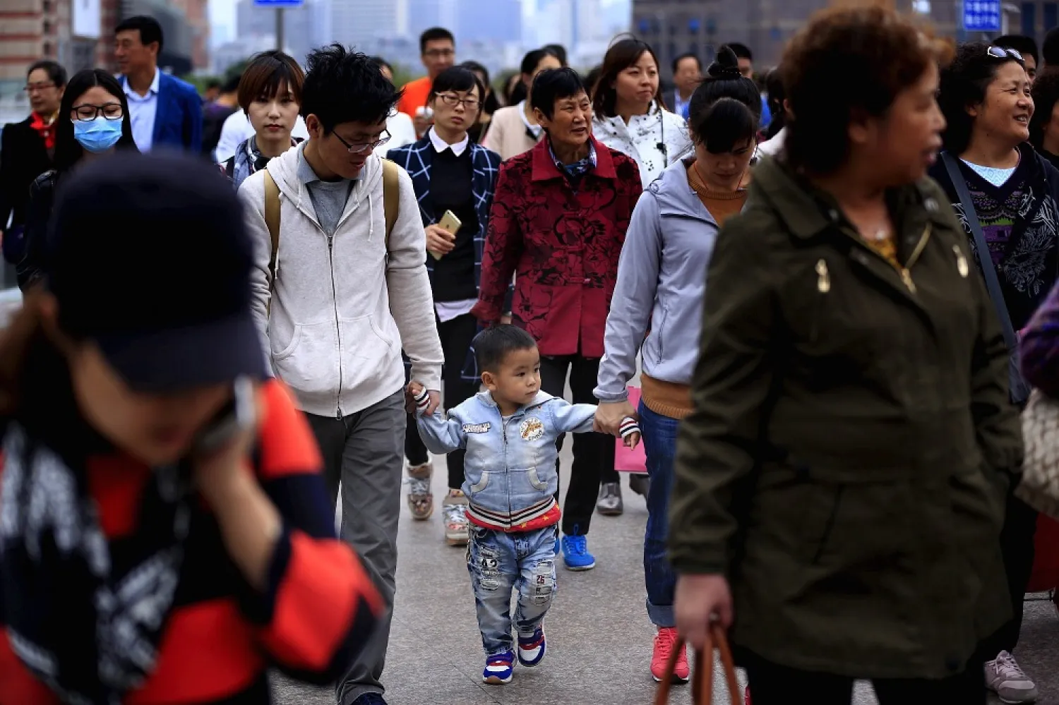 A little boy walks with his parents on a bridge in Shanghai, China. (Reuters)