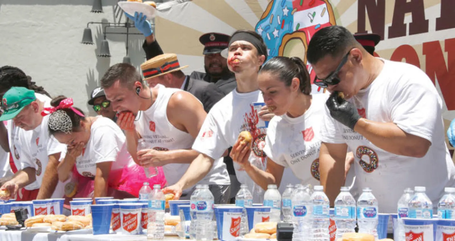 مات ستوني (الثالث من اليمين) الفائز في مسابقة تناول حلوى الدونت في هوليوود بولاية كاليفورنيا (إ.ب.أ)