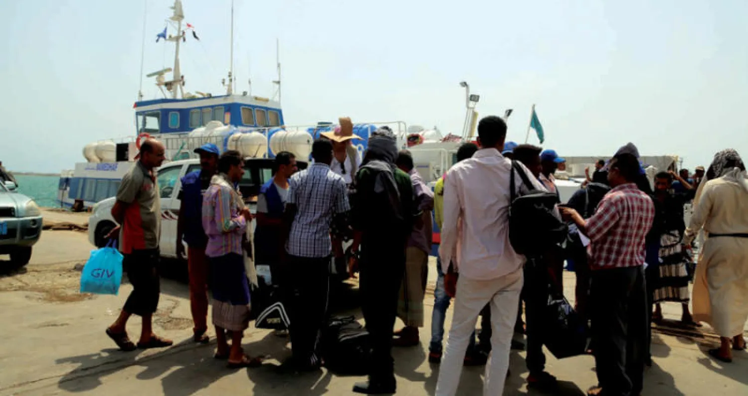 موظفو جمارك يتفحصون أمتعة مهاجرين إثيوبيين قبل أن يستقلوا سفينة في ميناء الحديدة أول من أمس (أ.ف.ب)