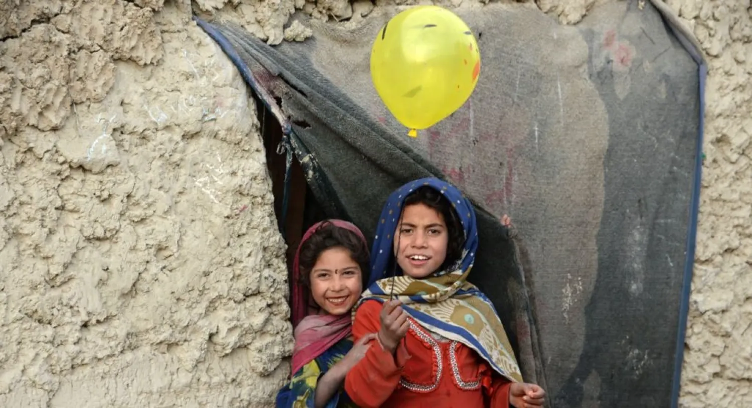 Internally displaced Afghan children play outside their temporary home at a refugee camp in Kabul, Afghanistan. (AFP)