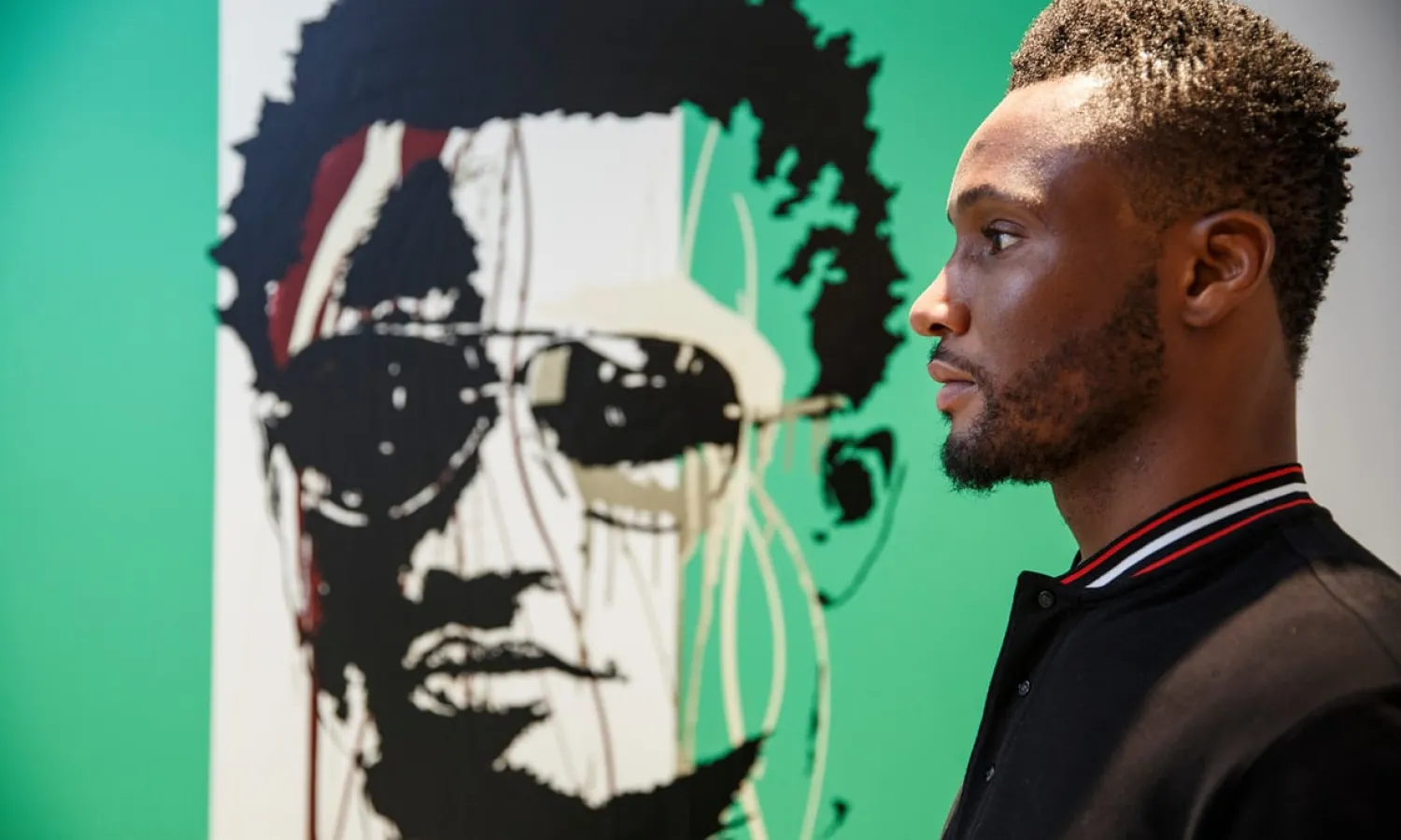 Mikel John Obi poses for a portrait next to a painting of himself in Nigeria colours at his house in Holland Park, west London. Nigeria play England at Wembley on Saturday. Photograph: Tom Jenkins/the Guardian