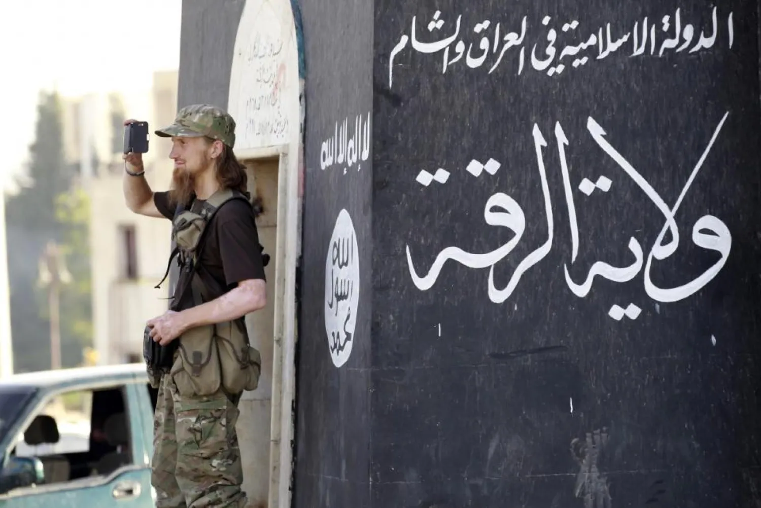  A militant extremist fighter uses a mobile phone to film a military parade in Syria’s northern Raqqa province, on June 30, 2014. Tens of thousands of foreign fighters traveled to Syria to live in ISIS’s so-called caliphate. REUTERS/Stringer 