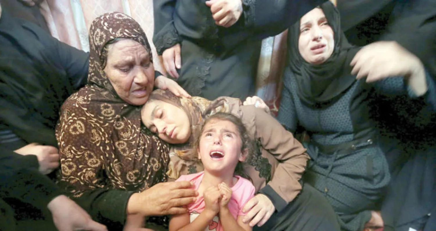 قريبات لهيثم الجمال (15 سنة) الذي قُتل برصاص جنود الاحتلال يوم الجمعة يواسون أمه خلال مراسم جنازته في مخيم رفح للاجئين بجنوب قطاع غزة أمس (رويترز)