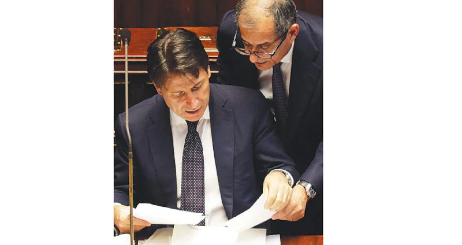 رئيس الوزراء الإيطالي الجديد غوسيبي كونتي  مع وزير الاقتصاد جيوفاني تيرا خلال اجتماع بالبرلمان (أ.ب)