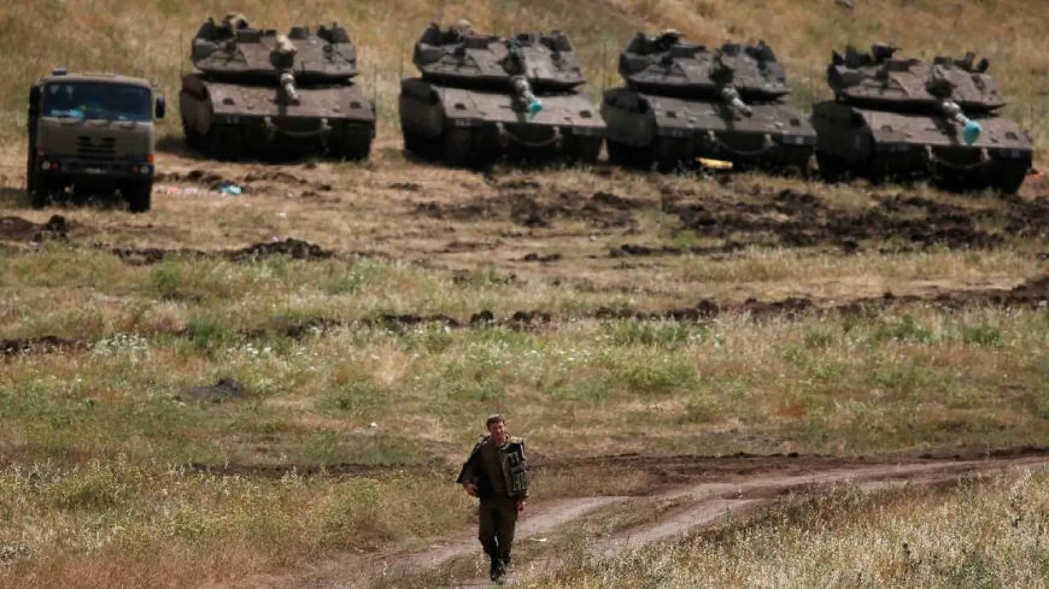 An Israeli soldier walks next to tanks at the occupied Golan Heights, Israel May 10, 2018\ RONEN ZVULUN/ REUTERS