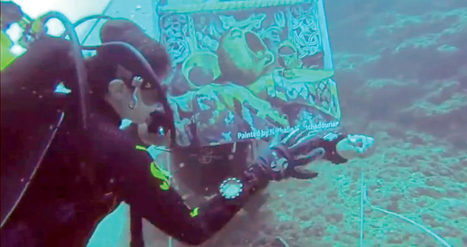 رواد المعرض من الغطاسين يستكشفون لوحاته التشكيلية