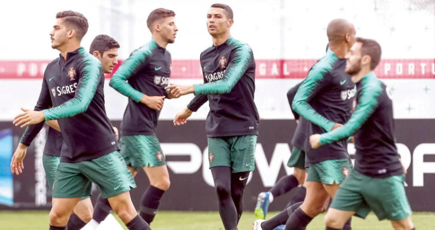 رونالدو نجم البرتغال يتوسط زملاءه خلاله التدريب أمس قبل مواجهة إسبانيا (إ.ب.أ)