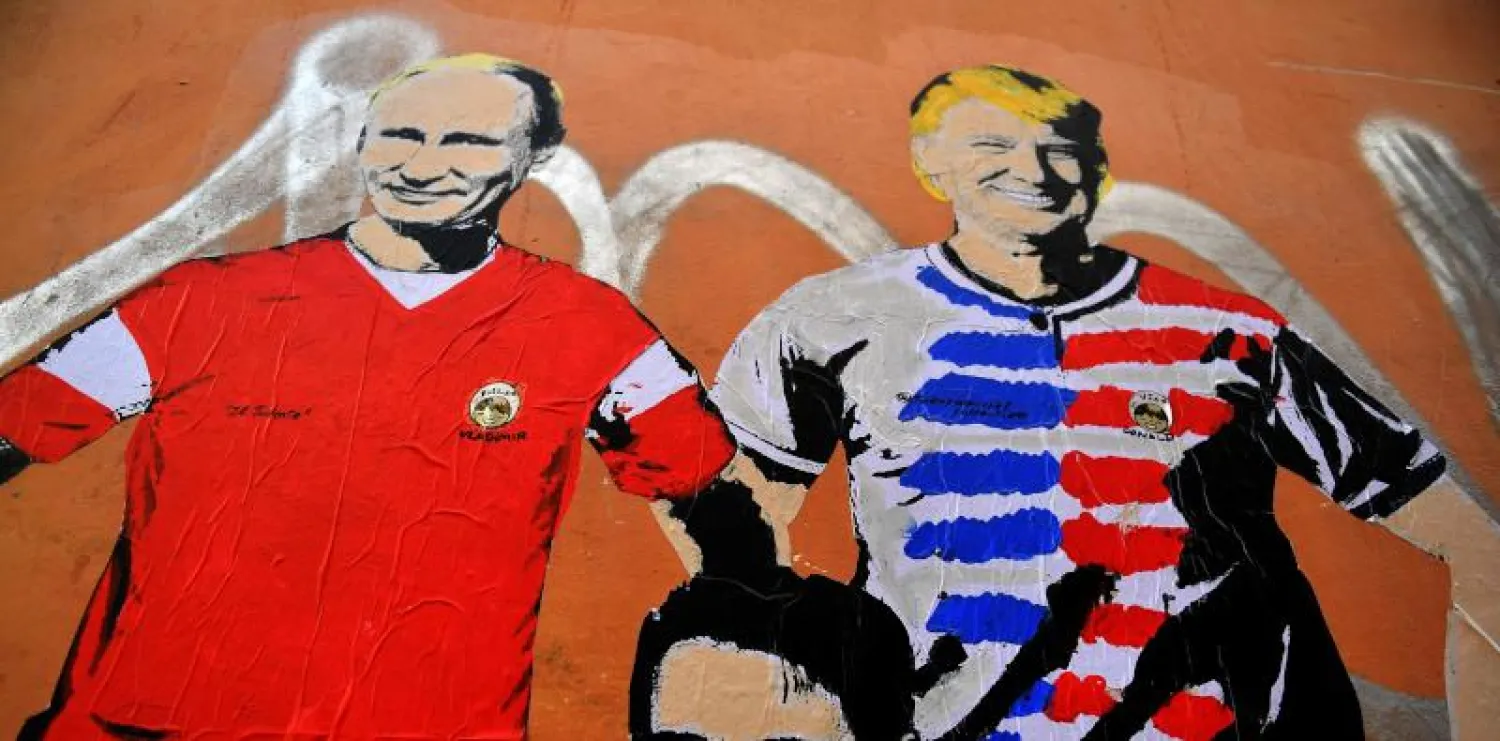 جدارية تحمل صورة للرئيس الأميركي والروسي في روما (أ.ف.ب)