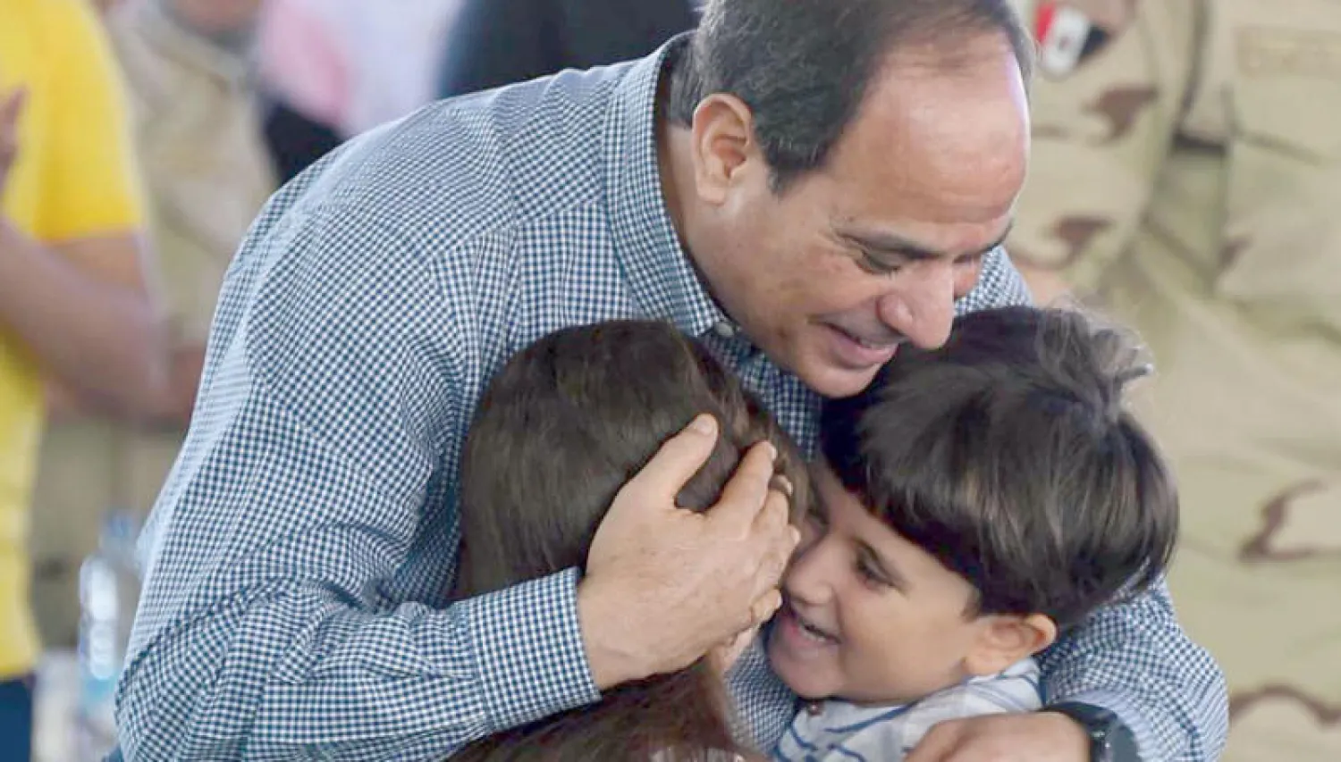 الرئيس المصري عبد الفتاح السيسي يحتضن اطفال أسر شهداء العمليات الإرهابية من الجيش والشرطة بعد صلاة عيد الفطر أمس («الشرق الأوسط»)