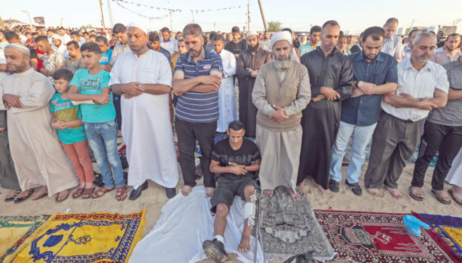 آلاف الفلسطينيين يؤدون صلاة العيد أمس بالمناطق الحدودية على مقربة من السياج الفاصل بين قطاع غزة وإسرائيل  (أ.ف.ب)