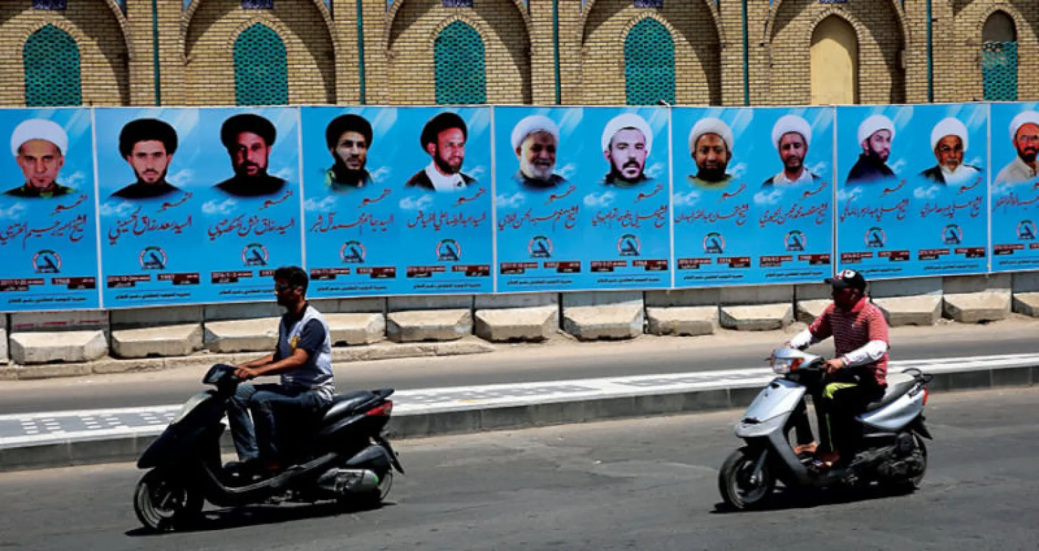 ملصق لصور رجال دين شيعة قتلوا على يد تنظيم «داعش» الإرهابي أمام جامع الخلاني في بغداد (أ.ف.ب)