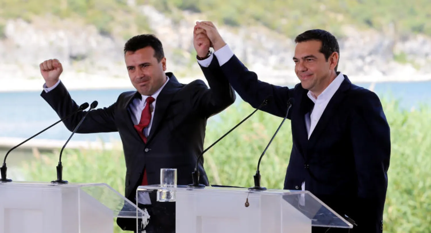 رئيس الوزراء اليوناني أليكسيس تسيبراس ورئيس الوزراء المقدوني زوران زائيف قبل توقيع الاتفاق (رويترز)
