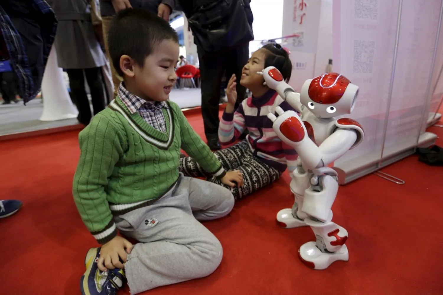 A child plays with a robot at the World Robot Conference in Beijing in November. (Reuters)