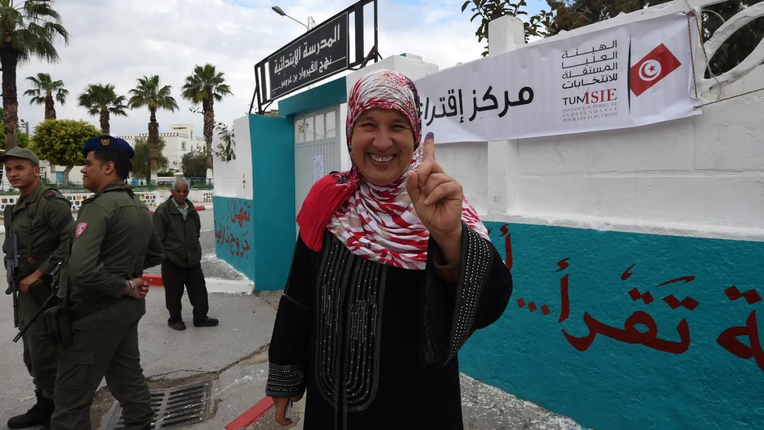 A Tunisian woman voter showcases her ink-stained finger after voting in municipal elections in May. (AFP)