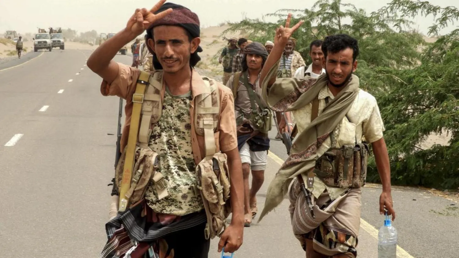 Yemeni pro-government forces flash the victory sign as they arrive in Al Duraihimi district, about nine kilometers south of Hodeidah international airport, on June 13, 2018. Nabil Hassan / AFP