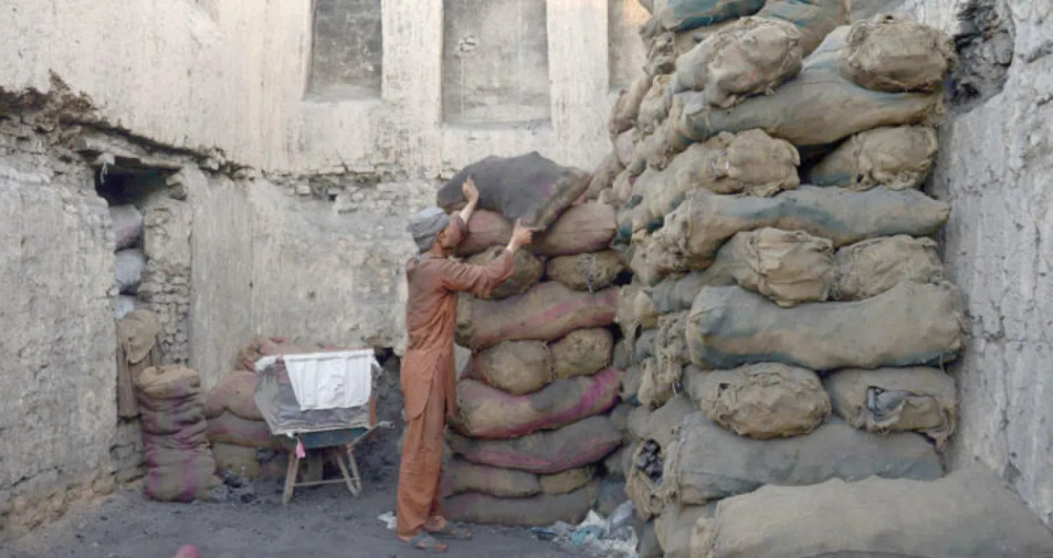 أفغاني يعمل في تجارة الفحم الحجري في سوق بمدينة مزار الشريف في شمال أفغانستان أول من أمس (أ.ف.ب)