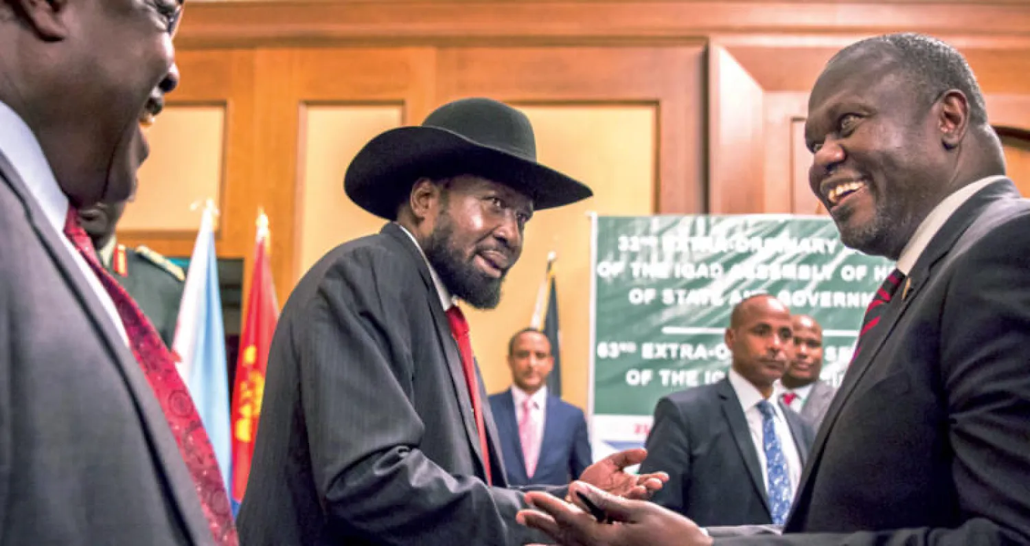 مصافحة بين سلفا كير (وسط) ورياك مشار خلال لقائهما في أديس أبابا أمس (أ.ب)