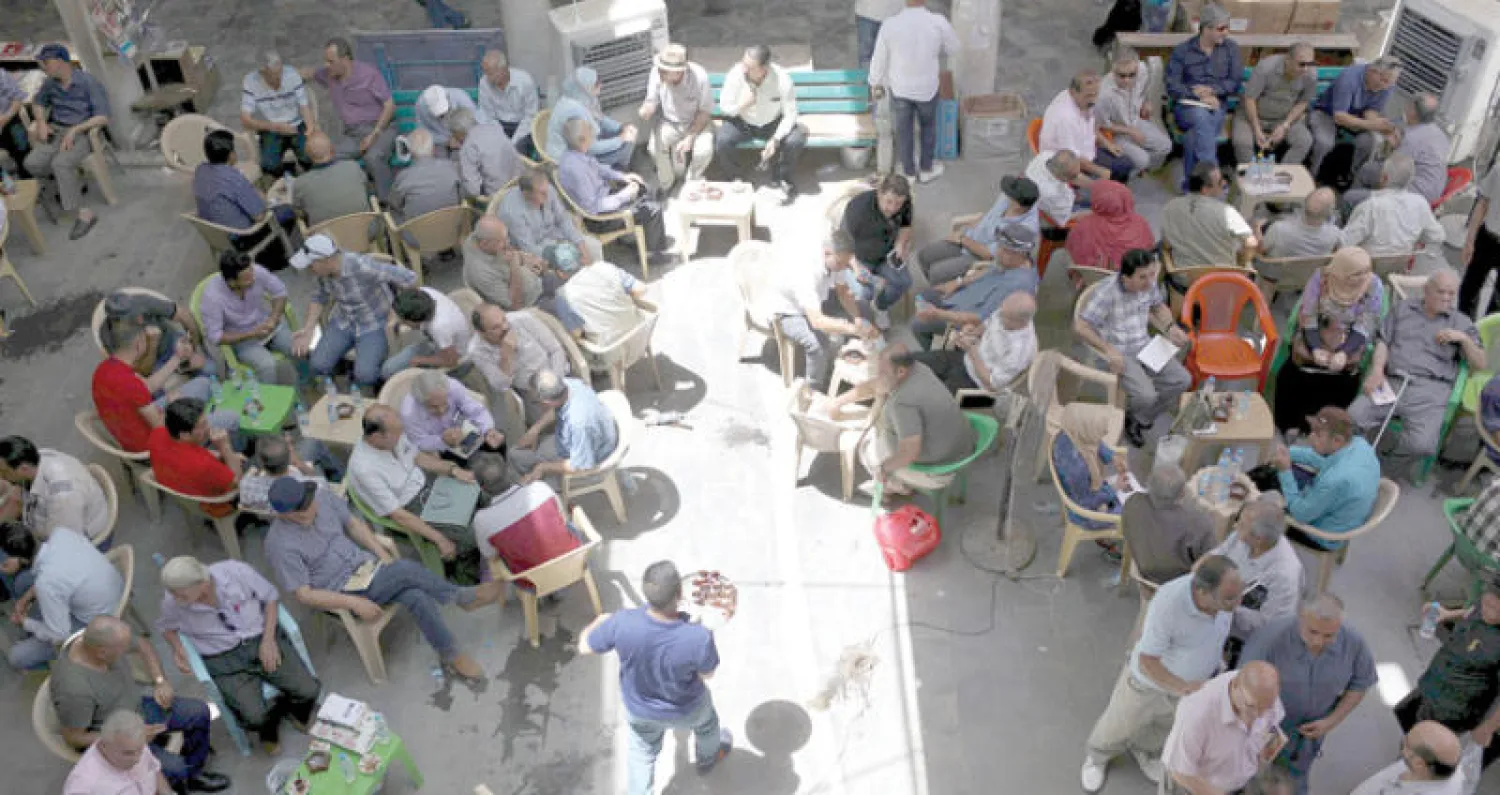 عراقيون في استراحة في شارع المتنبي الشهير وسط بغداد (رويترز)