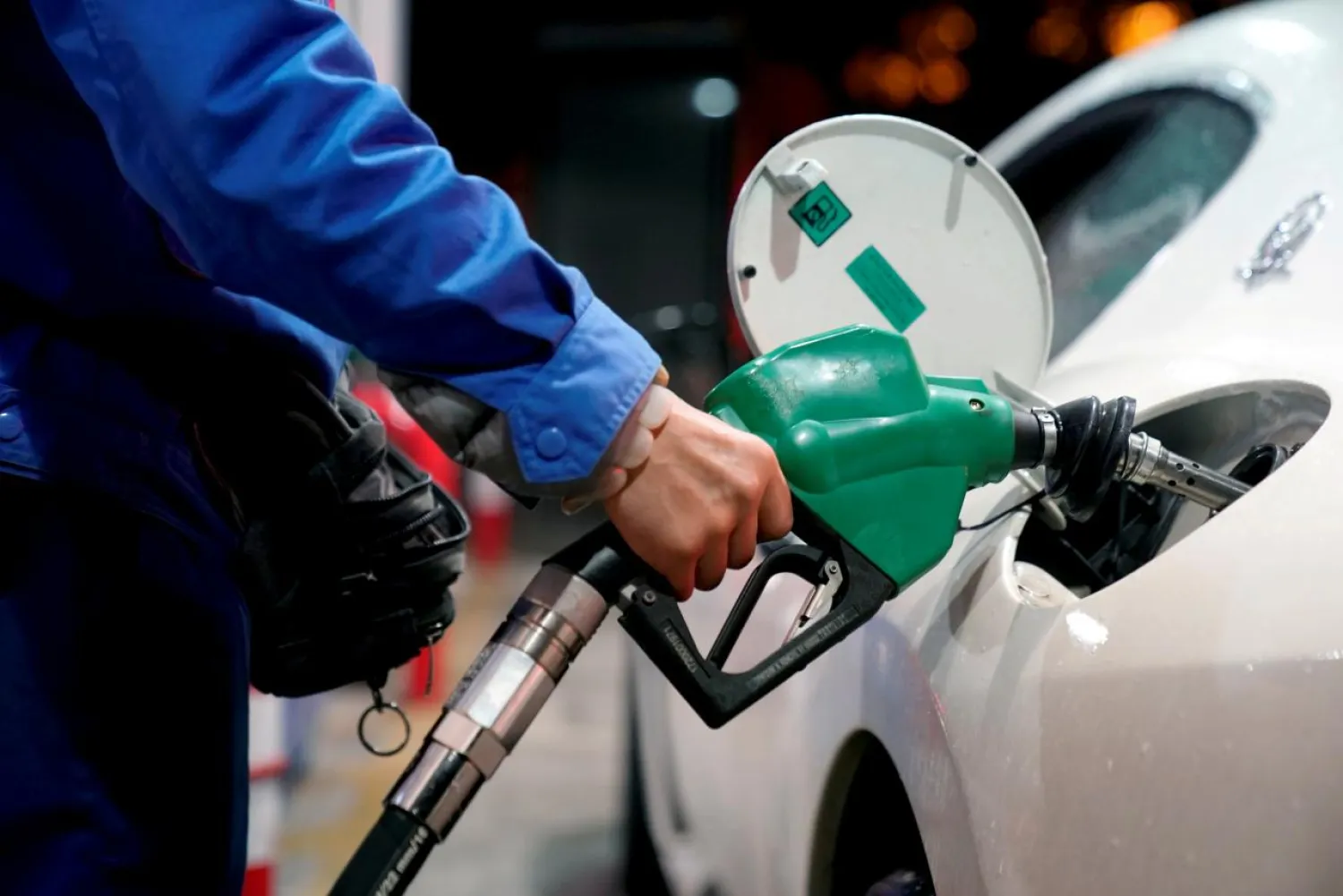 FILE PHOTO: A gas station attendant pumps fuel into a customer's car at a gas station. REUTERS/Aly Song