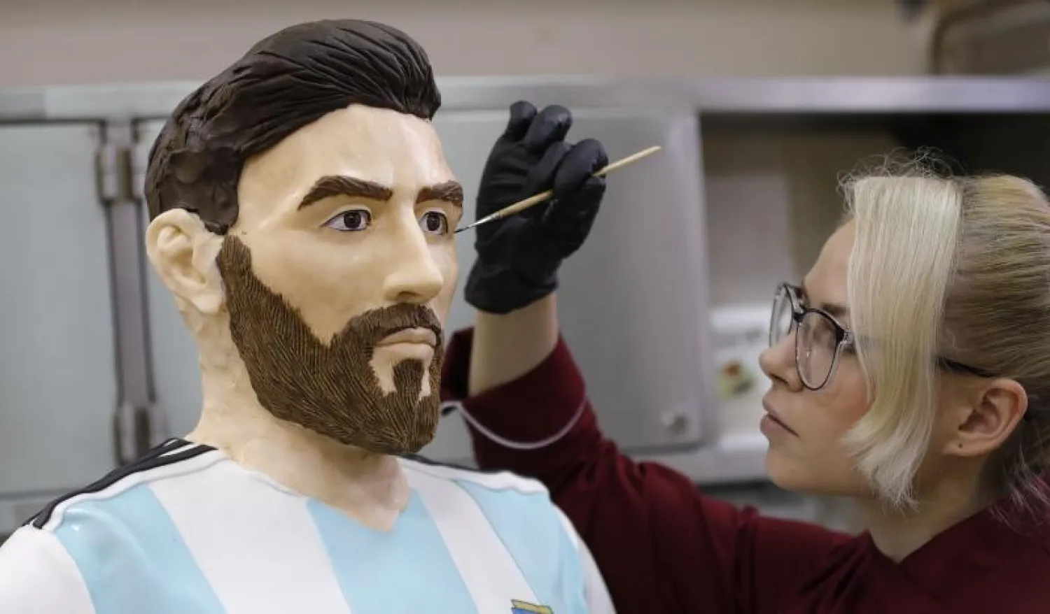 اللمسات النهائية على تمثال الشوكولاته لميسي بمناسبة عيد ميلاده (رويترز)