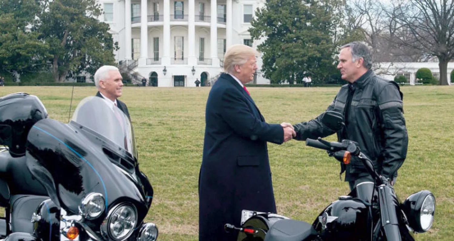 دونالد ترمب يحيي رئيس شركة «هارلي ديفيدسون» في حديقة البيت الأبيض في فبراير الماضي (أ.ف.ب)