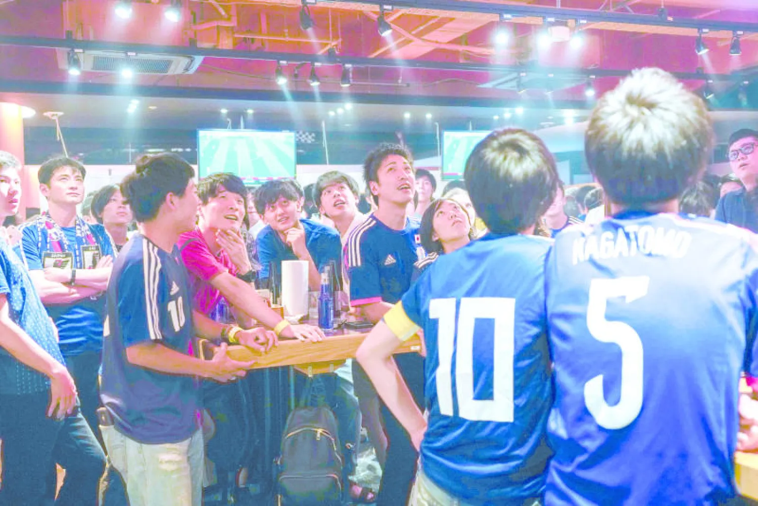 جماهير يابانية تتابع مباراة منتخب بلادهم أمام بولندا بأحد المطاعم في طوكيو (إ.ب.أ)