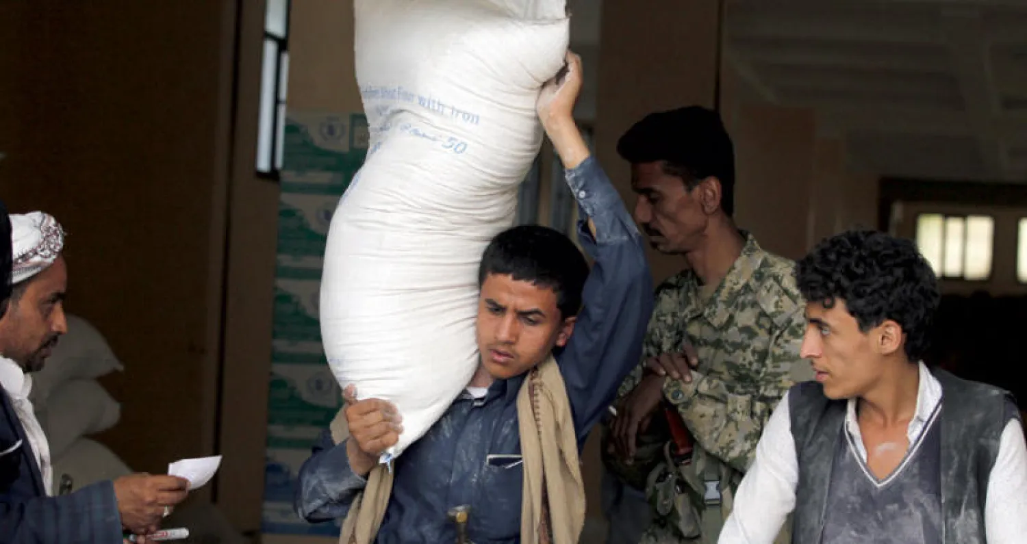 يمنيون لدى تلقيهم مساعدات إغاثية في صنعاء (إ.ب.أ)