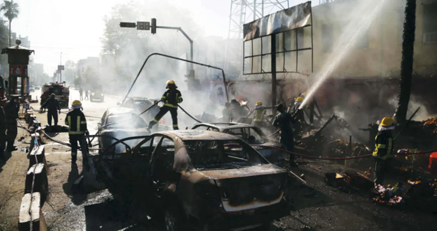 يطفئون حريقاً في مكان التفجير (إ.ب.أ)