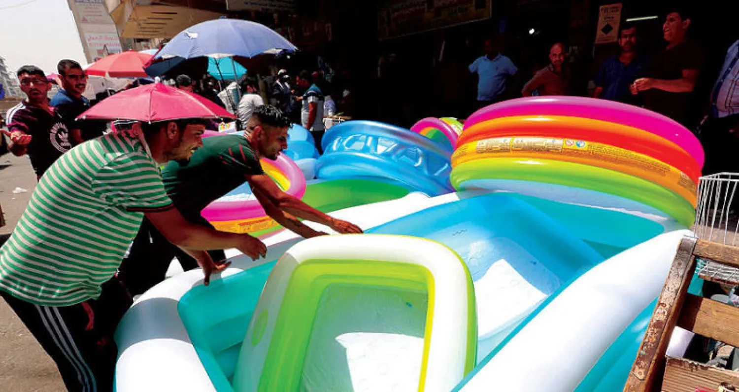 مسبح متنقل للأطفال بوسط بغداد لمواجهة سخونة الجو (إ.ب.أ)