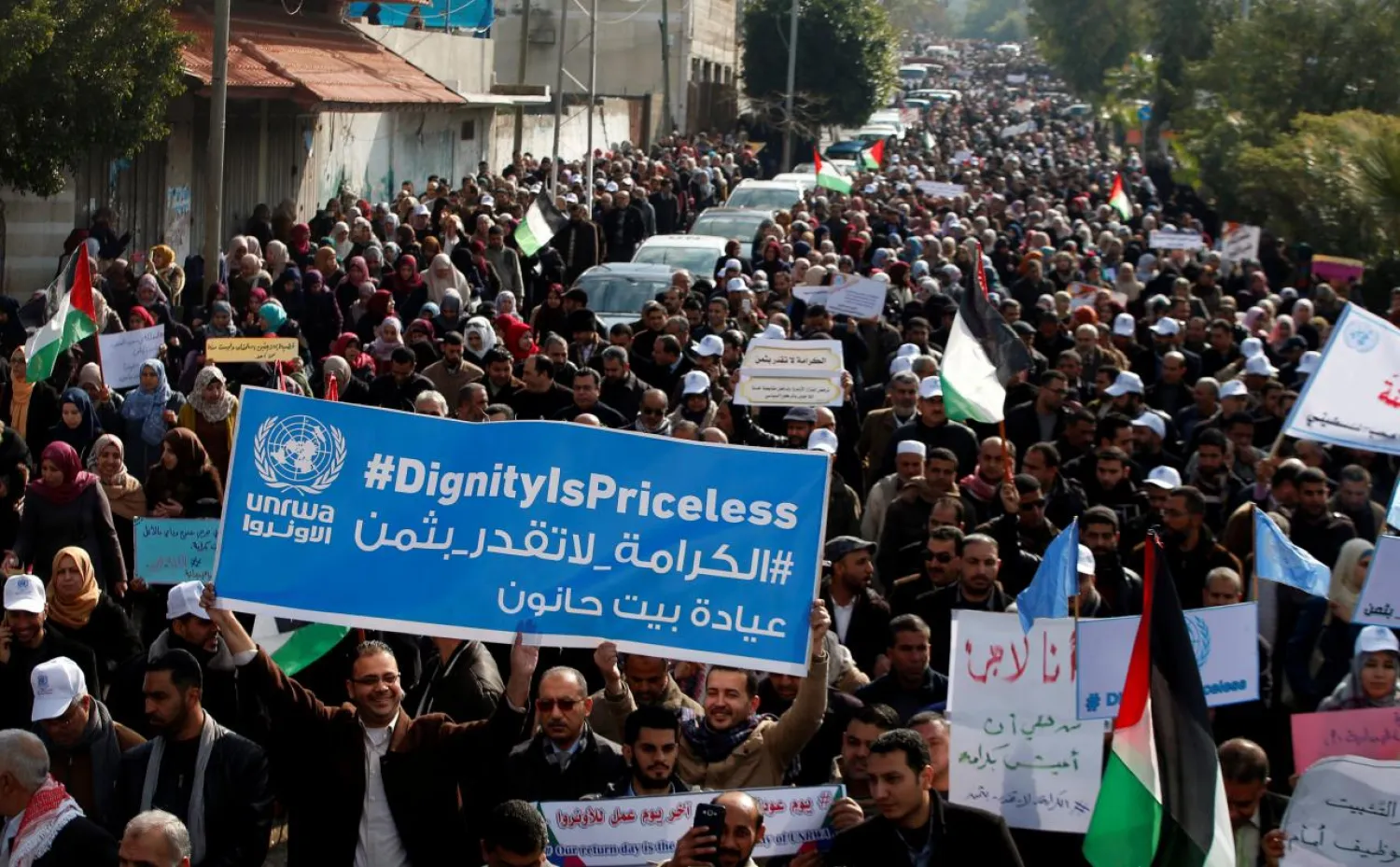 Palestinian employee of United Nations Relief and Works Agency (UNRWA) hold a sign during a protest against a US decision to cut aid, in Gaza City January 29, 2018. REUTERS/Mohammed Salem

