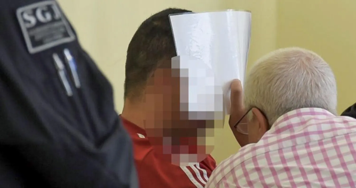 المغربي عبد الرحمن د. خلال مثوله أمام محكمة تزفيكاو وهو يغطي وجهه بملف