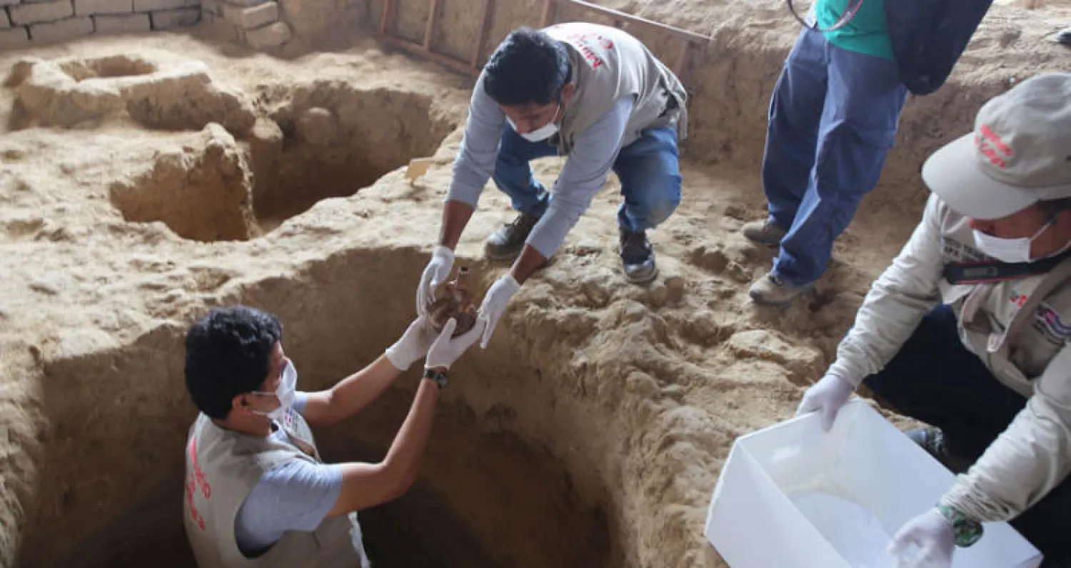 أثريون يعملون في موقع المقابر الهرمية التي عثر عليها بعيداً عن مقر إمبراطورية الإنكا (أ.ف.ب)